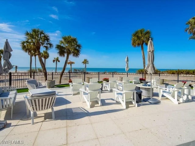 view of patio featuring fence, an outdoor living space, and a water view