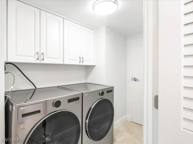 laundry area featuring cabinet space, independent washer and dryer, and baseboards