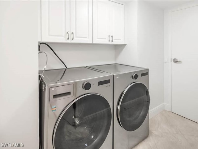 laundry area with cabinet space, baseboards, and separate washer and dryer