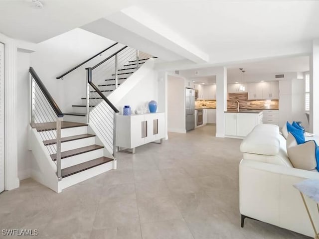 living room with beam ceiling and stairs