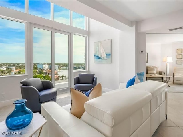 living room featuring light tile patterned flooring, visible vents, and baseboards