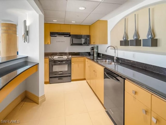 kitchen with dark countertops, a sink, black appliances, a drop ceiling, and ventilation hood