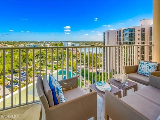 balcony with an outdoor living space and a water view