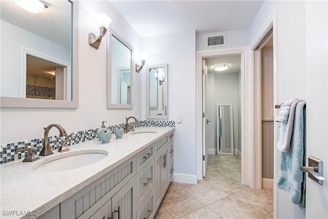 bathroom with visible vents, a sink, and double vanity