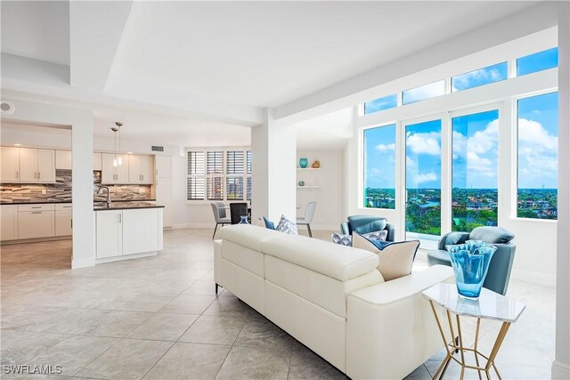 living area featuring a healthy amount of sunlight, light tile patterned floors, baseboards, and visible vents