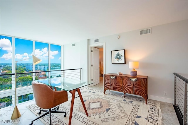 office area with a wall of windows, visible vents, and baseboards