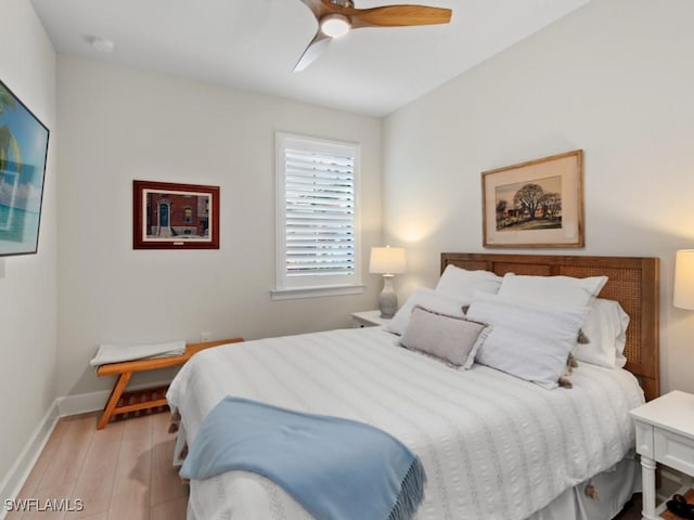 bedroom featuring ceiling fan, baseboards, and light wood-style floors