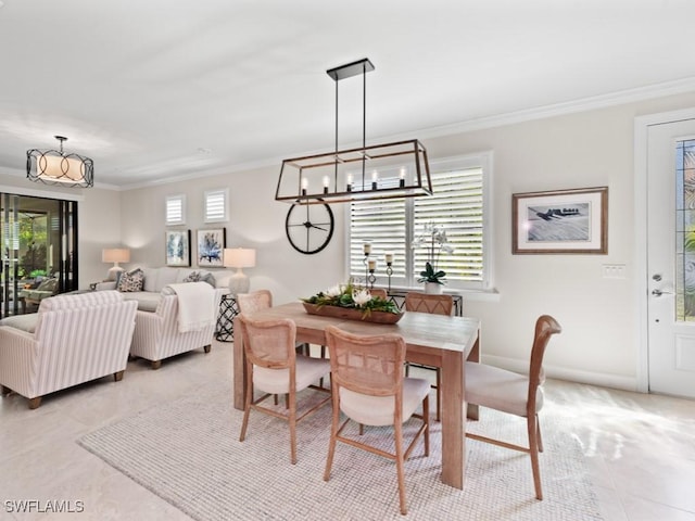 dining room featuring a notable chandelier, baseboards, light tile patterned floors, and ornamental molding