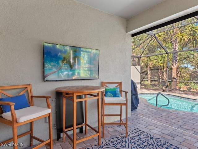 exterior space featuring glass enclosure, a patio area, and outdoor dry bar