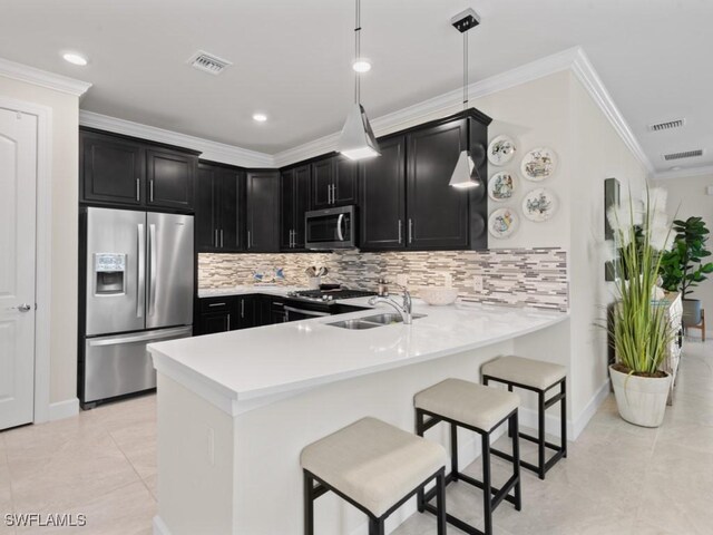 kitchen featuring dark cabinetry, visible vents, a peninsula, light countertops, and appliances with stainless steel finishes