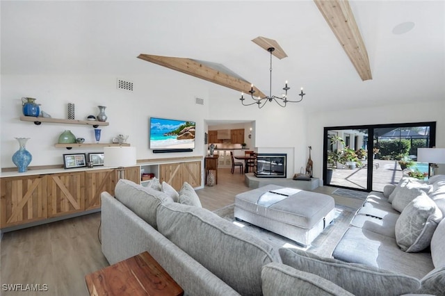 living room with visible vents, a notable chandelier, beamed ceiling, and light wood-style flooring