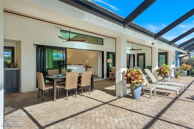 view of patio / terrace with outdoor dining space, a lanai, and ceiling fan