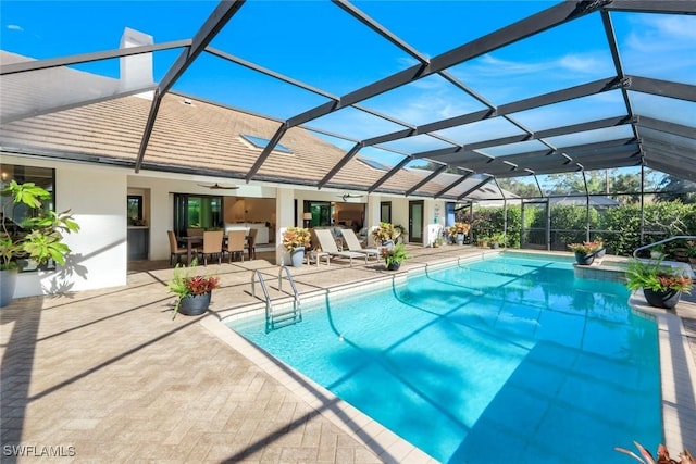 pool with a lanai, ceiling fan, and a patio