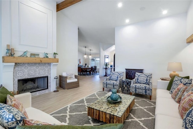 living room featuring beam ceiling, recessed lighting, a fireplace, wood finished floors, and high vaulted ceiling