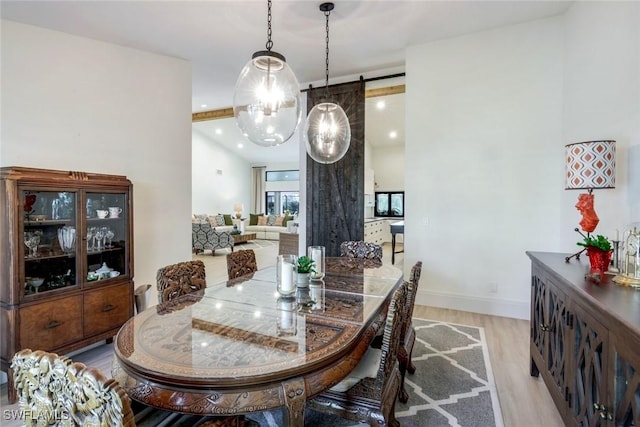 dining area featuring recessed lighting, light wood-style flooring, baseboards, and a barn door