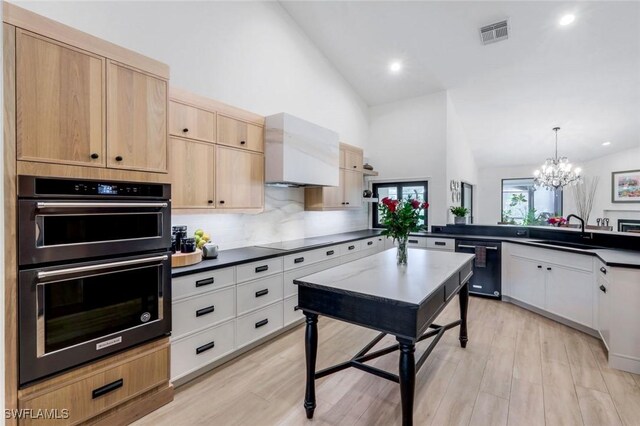 kitchen with black appliances, dark countertops, visible vents, and a sink