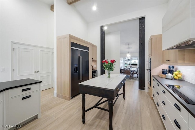 kitchen with dark countertops, black appliances, and light wood-style floors