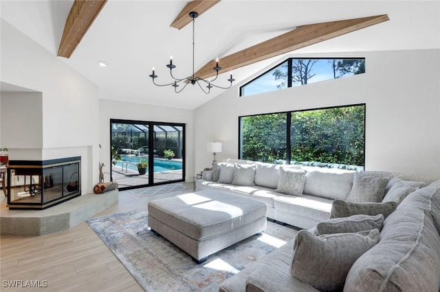 living room featuring a multi sided fireplace, beamed ceiling, plenty of natural light, and wood finished floors