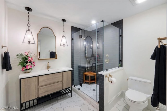 full bathroom featuring a shower stall, baseboards, toilet, tile patterned floors, and vanity