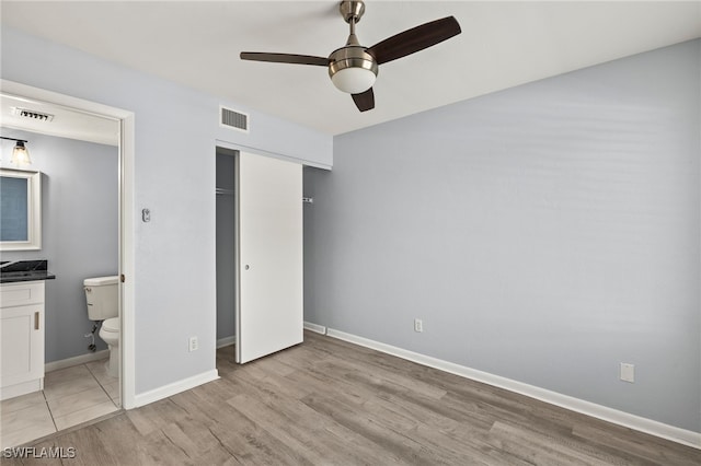 unfurnished bedroom featuring a closet, visible vents, baseboards, and light wood-style floors