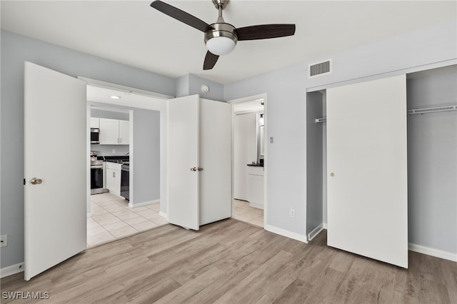 unfurnished bedroom featuring baseboards, visible vents, light wood-style flooring, a closet, and connected bathroom