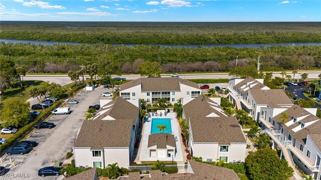 aerial view featuring a wooded view, a water view, and a residential view