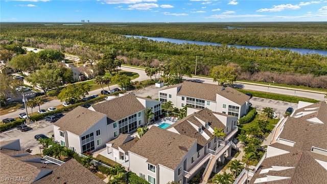 birds eye view of property featuring a wooded view, a water view, and a residential view