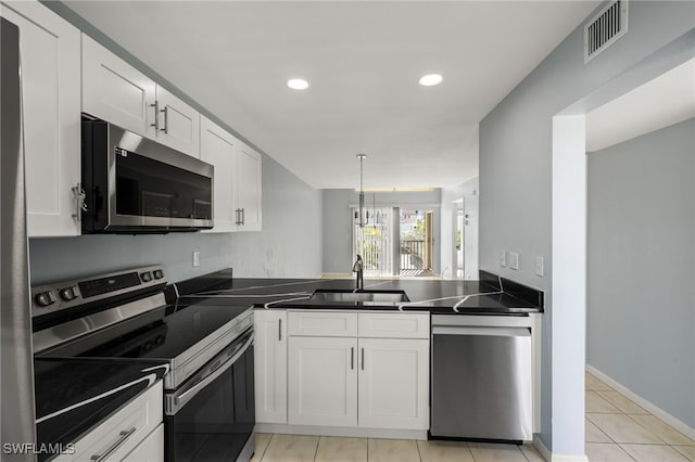 kitchen featuring a sink, dark countertops, visible vents, and stainless steel appliances