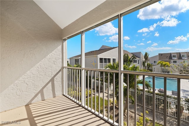 balcony featuring a residential view and a water view