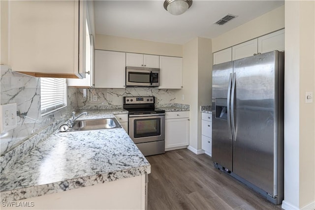 kitchen featuring tasteful backsplash, visible vents, light countertops, appliances with stainless steel finishes, and a sink