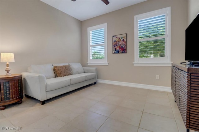 living room with baseboards, a ceiling fan, and tile patterned flooring