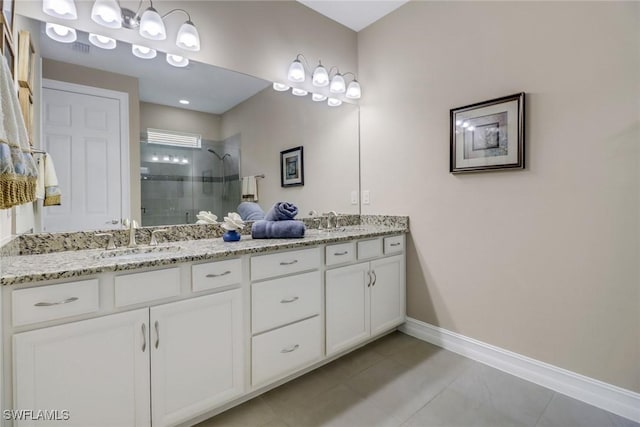 bathroom with tile patterned flooring, a shower stall, baseboards, double vanity, and a sink