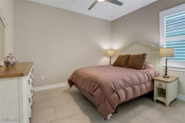 bedroom featuring light tile patterned floors, baseboards, and ceiling fan