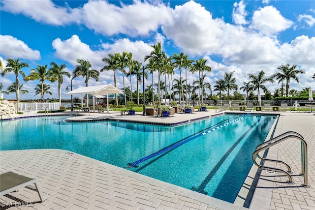 pool with a patio and fence