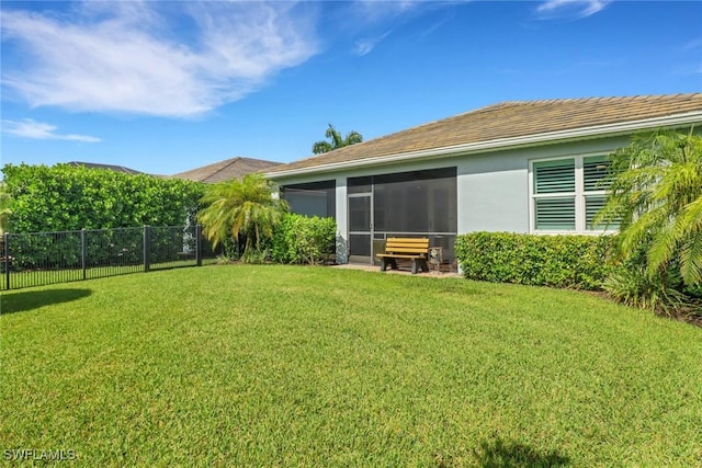 view of yard featuring a sunroom and fence