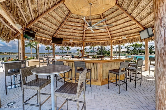 view of patio / terrace featuring a gazebo, outdoor dry bar, and a community pool