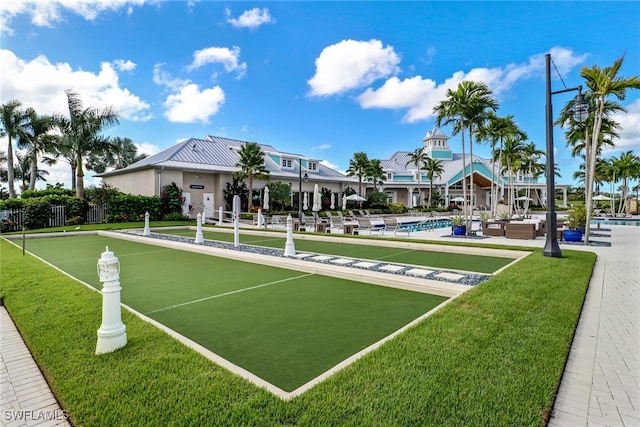 view of property's community featuring a lawn and a pool