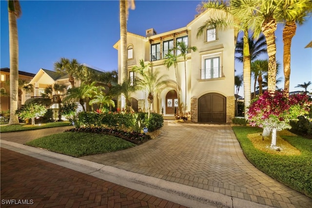 view of property with decorative driveway and a garage