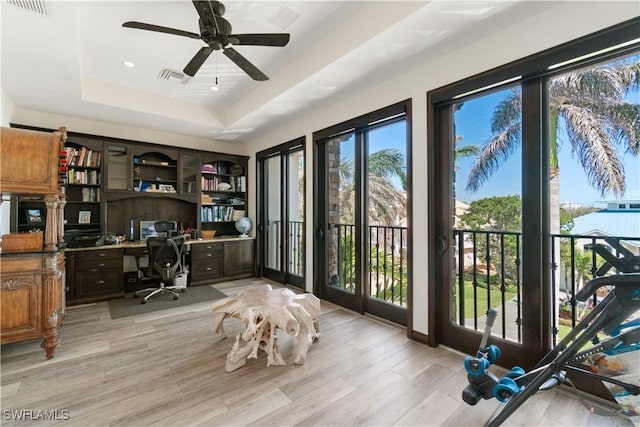 office with a wealth of natural light, visible vents, a raised ceiling, and a ceiling fan