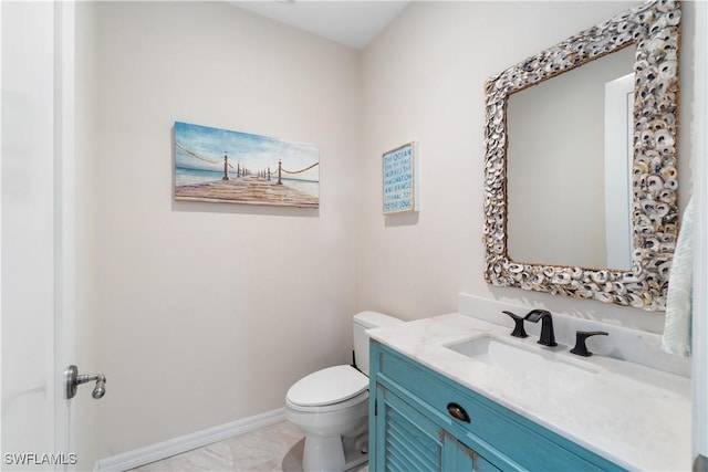 half bathroom featuring baseboards, toilet, and vanity