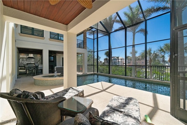 view of pool with glass enclosure, a patio area, a fenced in pool, and ceiling fan