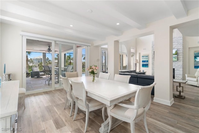 dining area with beamed ceiling, a healthy amount of sunlight, and light wood-style floors