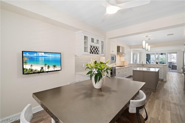 dining space featuring visible vents, baseboards, light wood-style flooring, and a ceiling fan