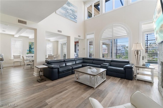 living area featuring baseboards, visible vents, and light wood-type flooring