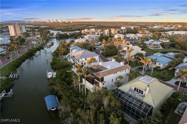 aerial view at dusk with a residential view and a water view