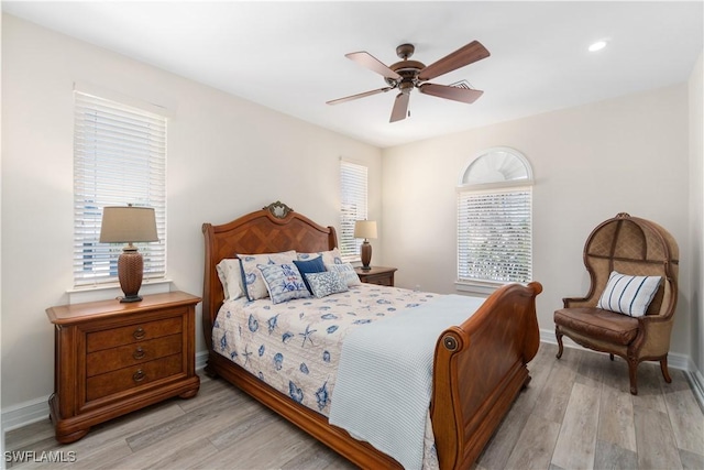 bedroom featuring light wood-style flooring, a ceiling fan, and baseboards