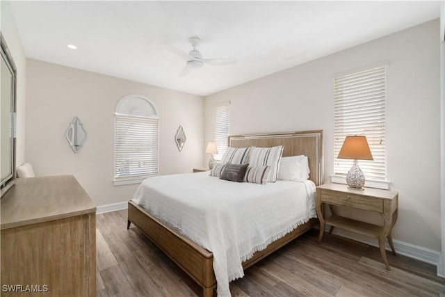 bedroom with a ceiling fan, baseboards, and wood finished floors