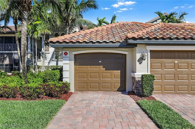 mediterranean / spanish-style home featuring stucco siding, decorative driveway, and a tile roof