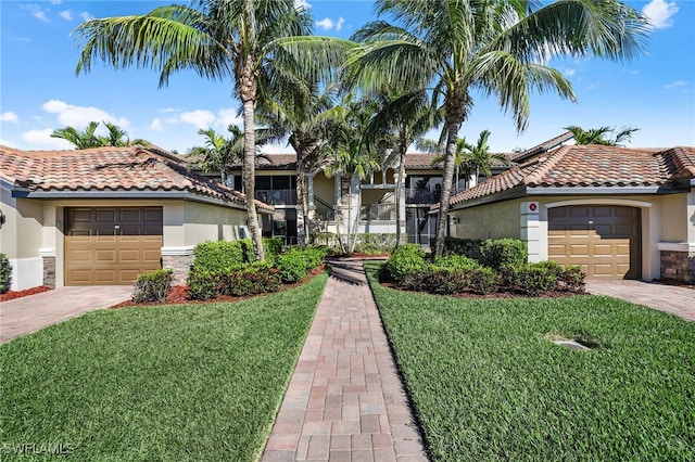 mediterranean / spanish-style house featuring a garage, a front yard, driveway, and stucco siding