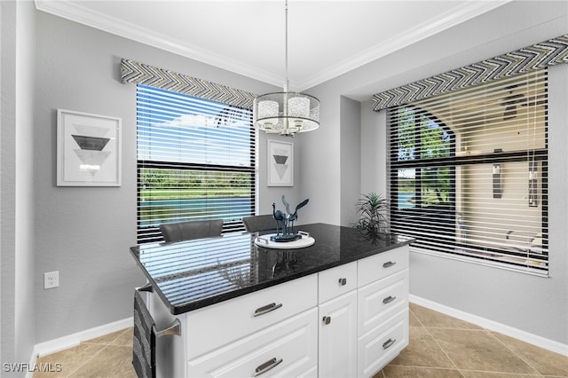 kitchen with white cabinetry, crown molding, baseboards, and a chandelier